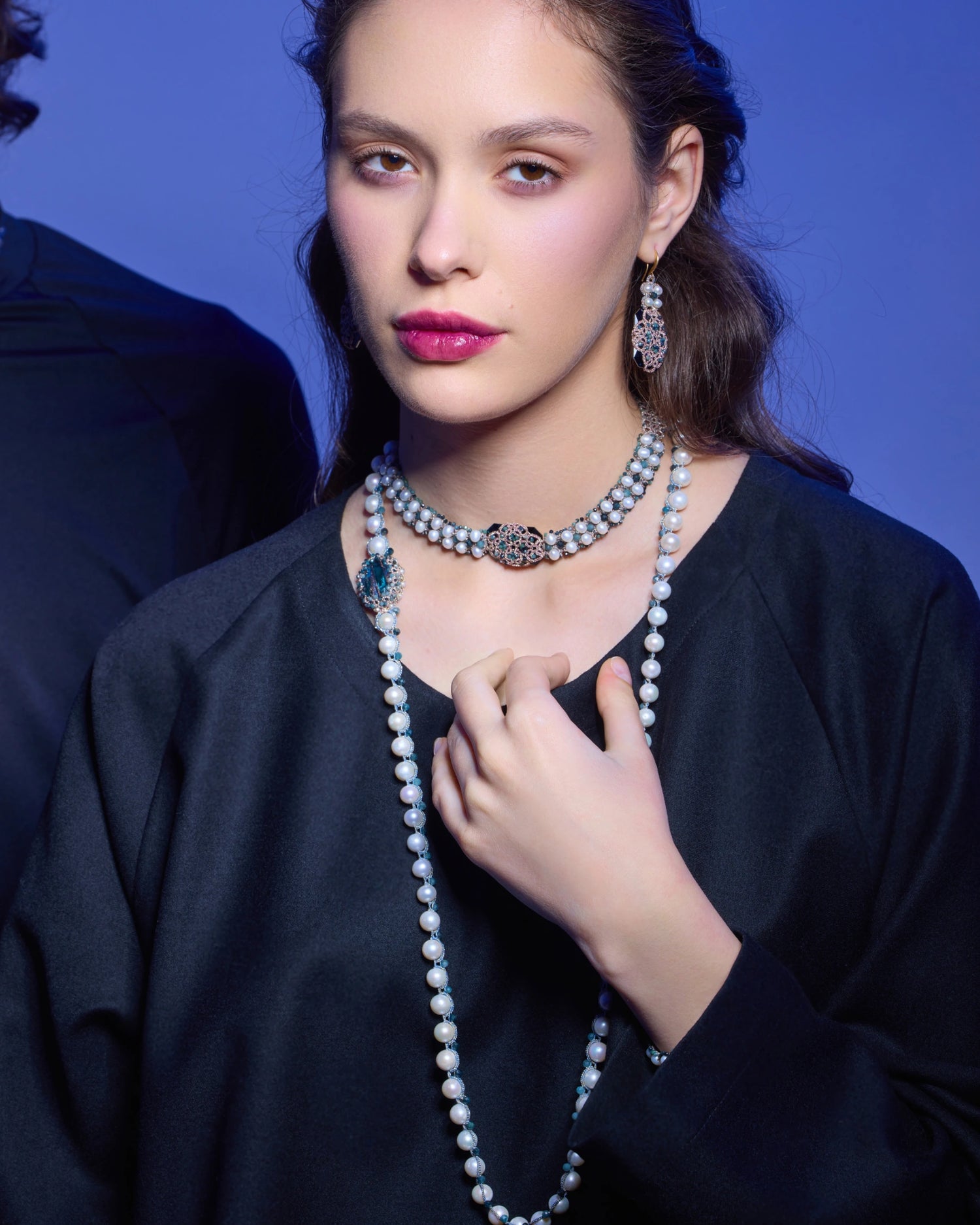 Blue silk choker with freshwater pearls, crystals, intricate detailing on a model against blue background.