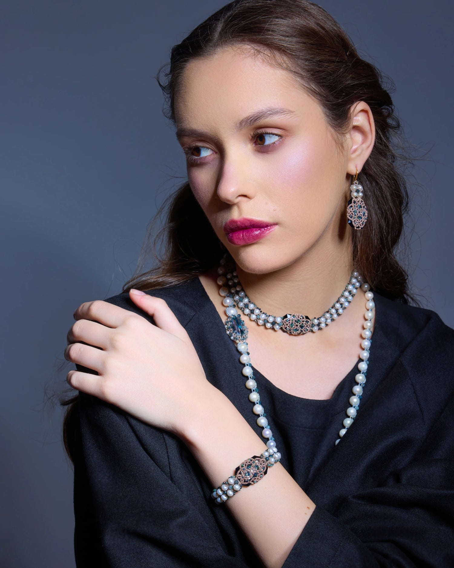 Elegant blue Bari earrings with intricate design and pearls, worn by model, side view showcasing detailed craftsmanship.