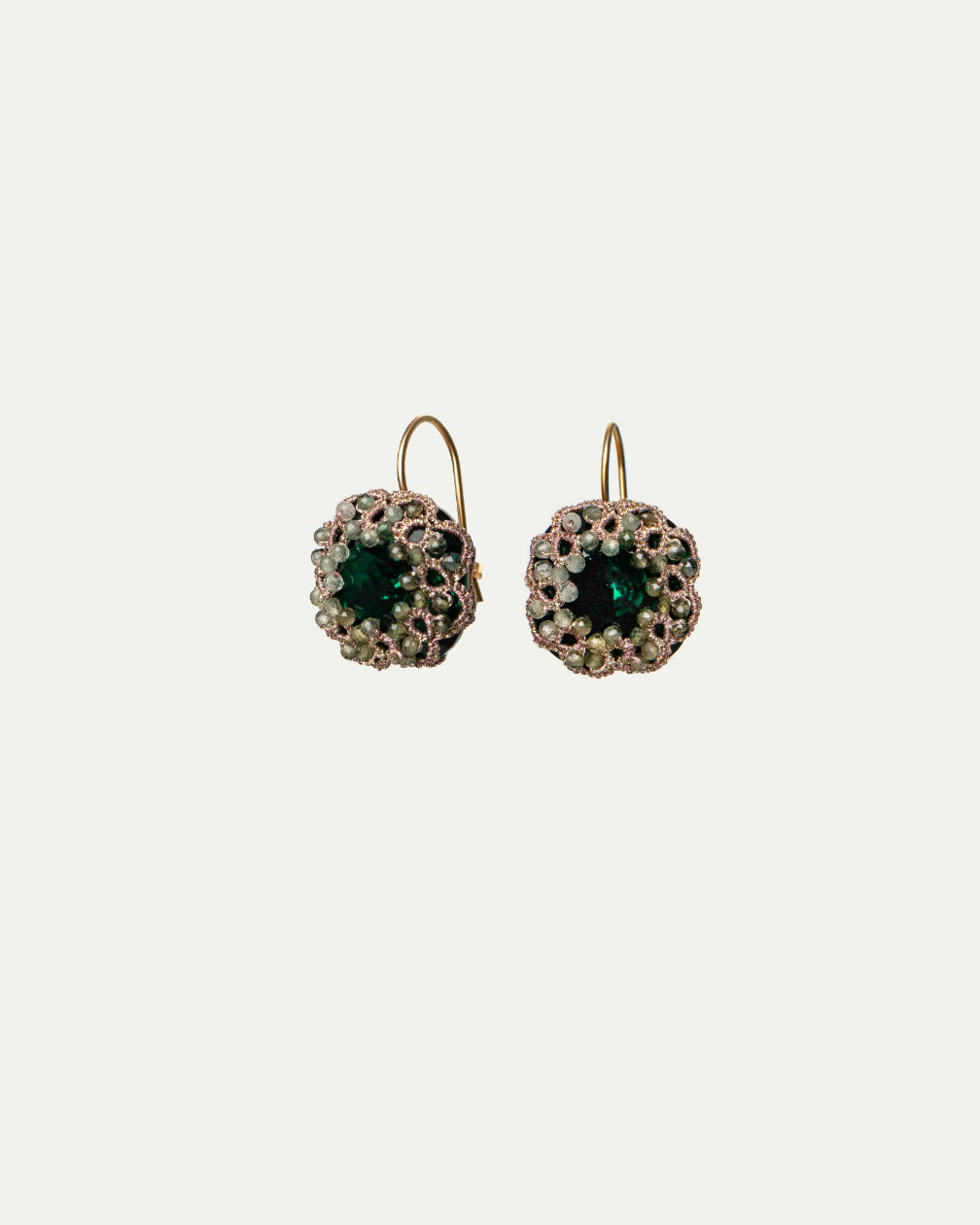 Gold hook earrings with green sapphire center, silk edge, crystal accents, silver detailing, intricate texture.