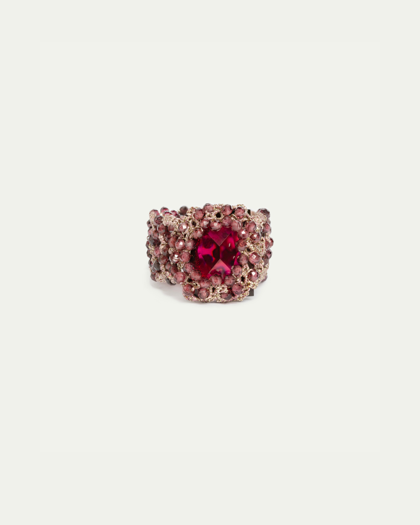 Gold ring with intricate red gemstone cluster setting, featuring a large central red gem.