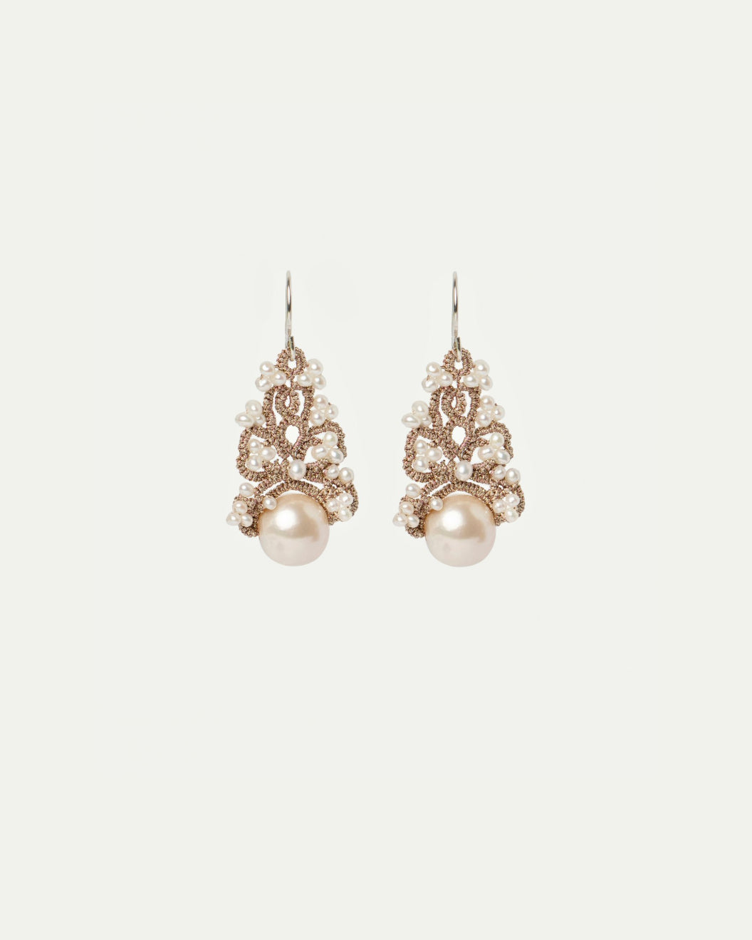 Elegant white Gillet earrings with intricate lace design and pearl accents, side view.