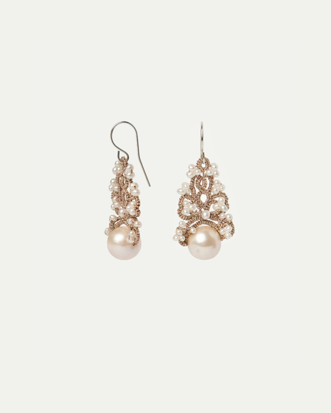 Silk silver earrings with white freshwater pearls, intricate detail, large pearl accents.