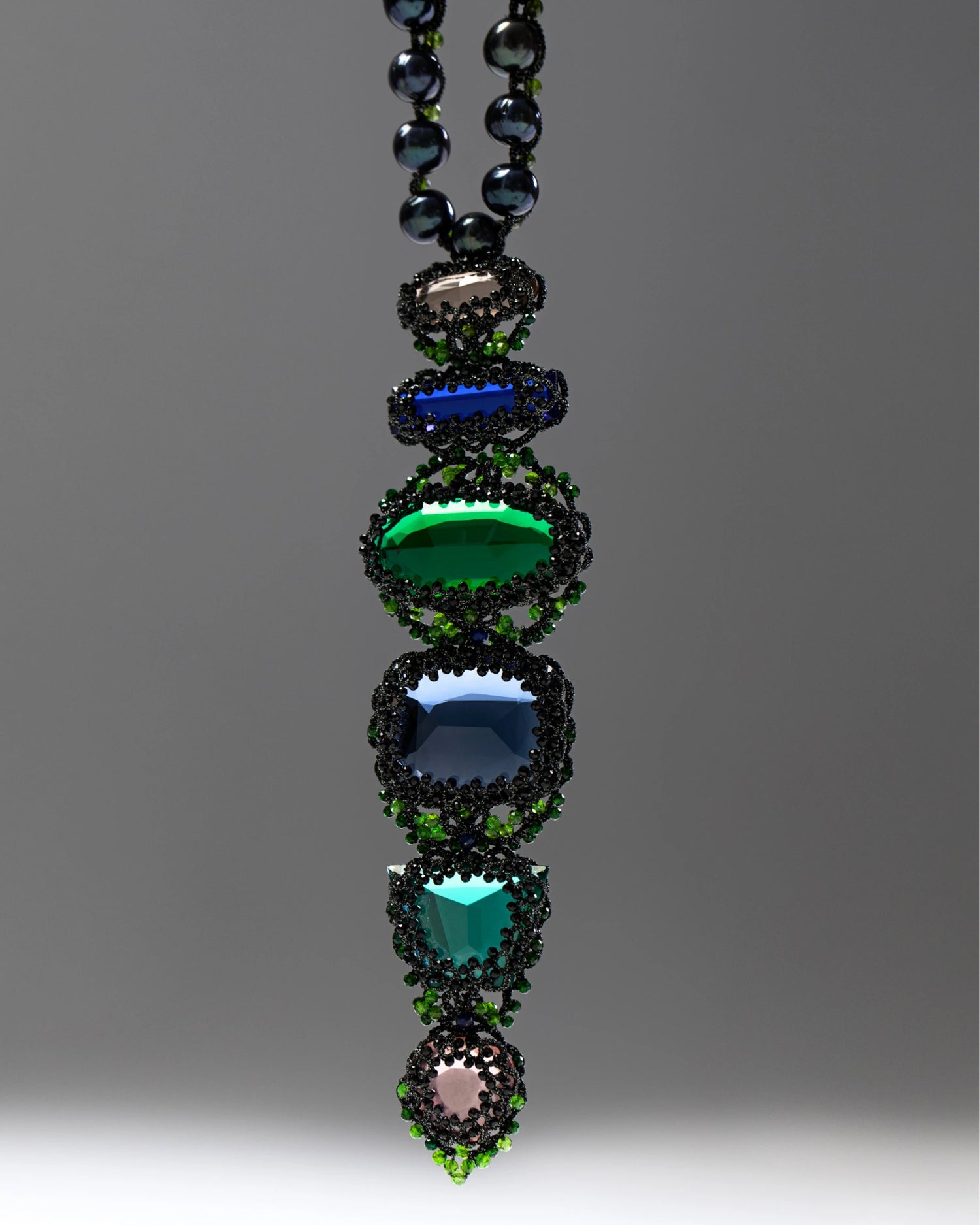 Black freshwater pearl necklace with faceted glass and pearl details, intricate beadwork, green accents.