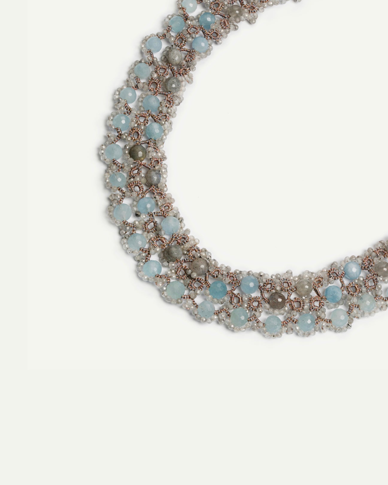 Blue gemstone necklace with intricate silver detailing viewed from the side.