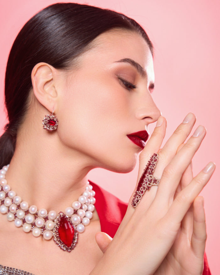 Red silk, garnet, and glass Hepburn ring detail showcasing intricate texture and design, size 57.