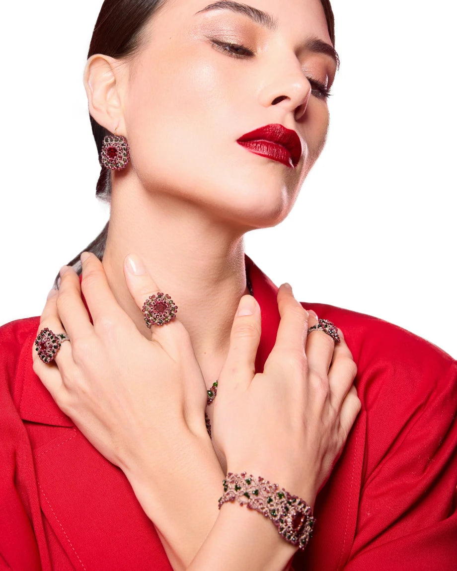 Red silk Lisa bracelet with pearls, crystals, and garnets displayed on wrist, intricate texture details.