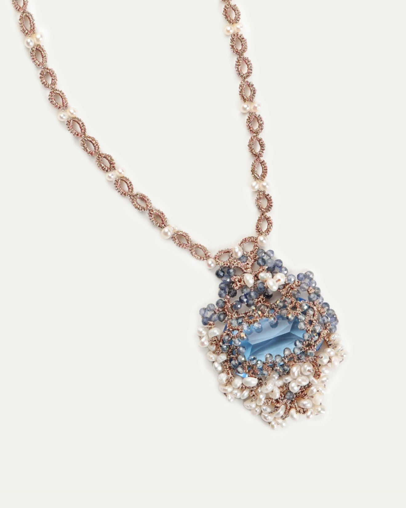 Blue NAYA necklace with pearls and intricate beadwork, featuring a blue stone pendant and delicate metal chain detailing.