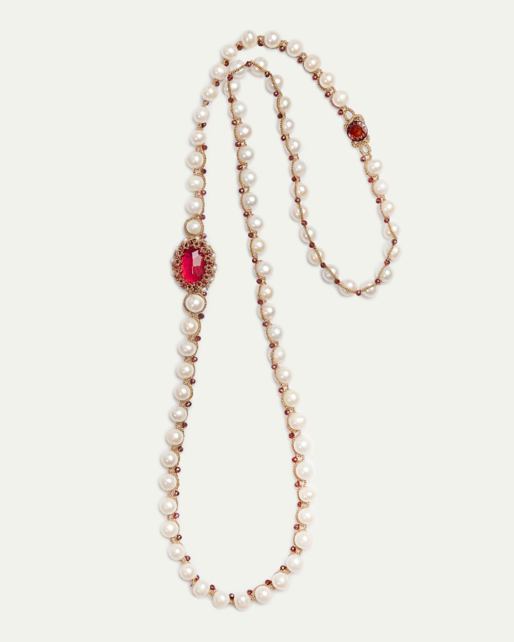 Silk and freshwater pearl pendant with garnet accents, featuring detailed textures and a rich red color.