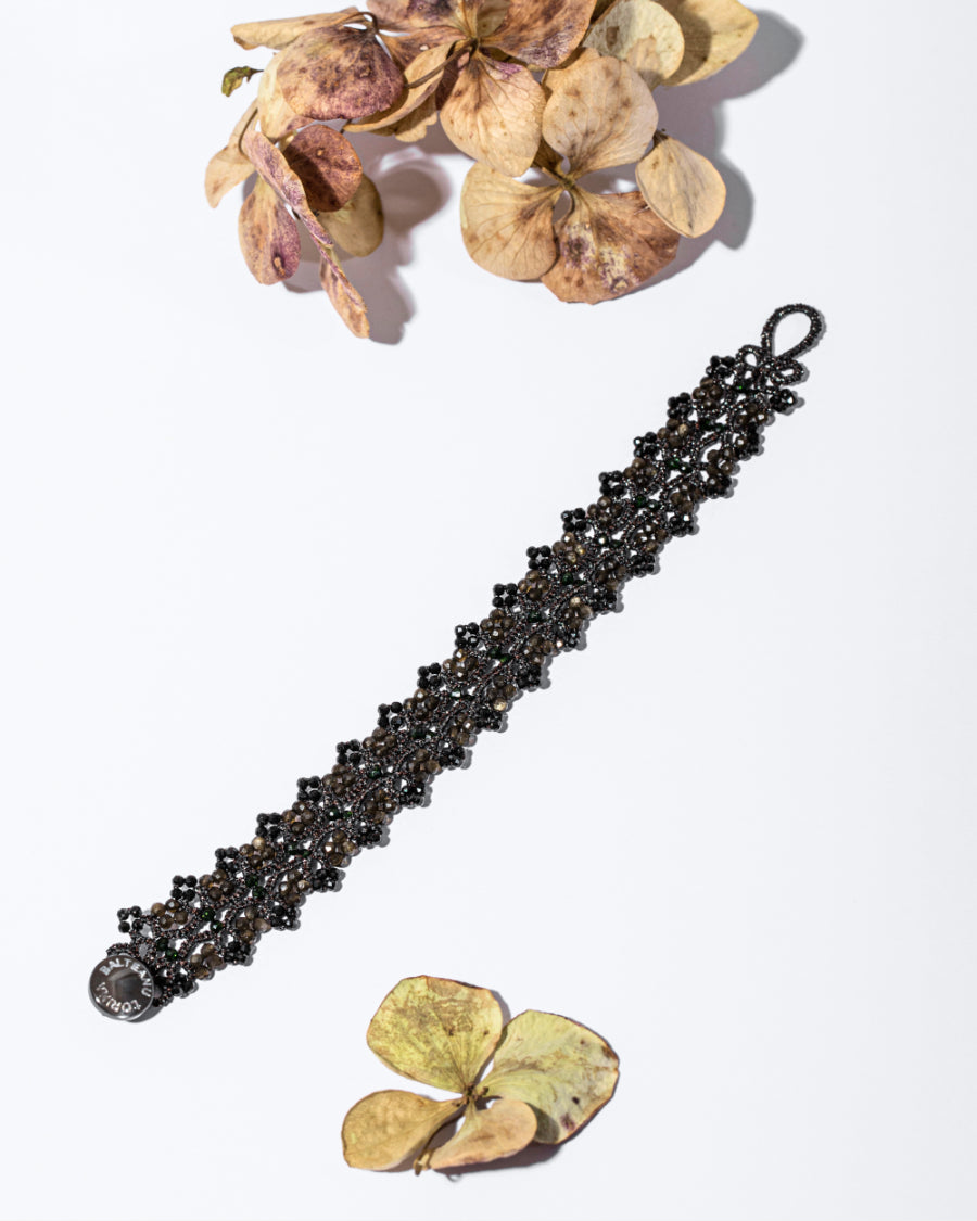 SOPHIE BRACELET with black tourmaline, obsidian, silk, and mother of pearl button on white background.