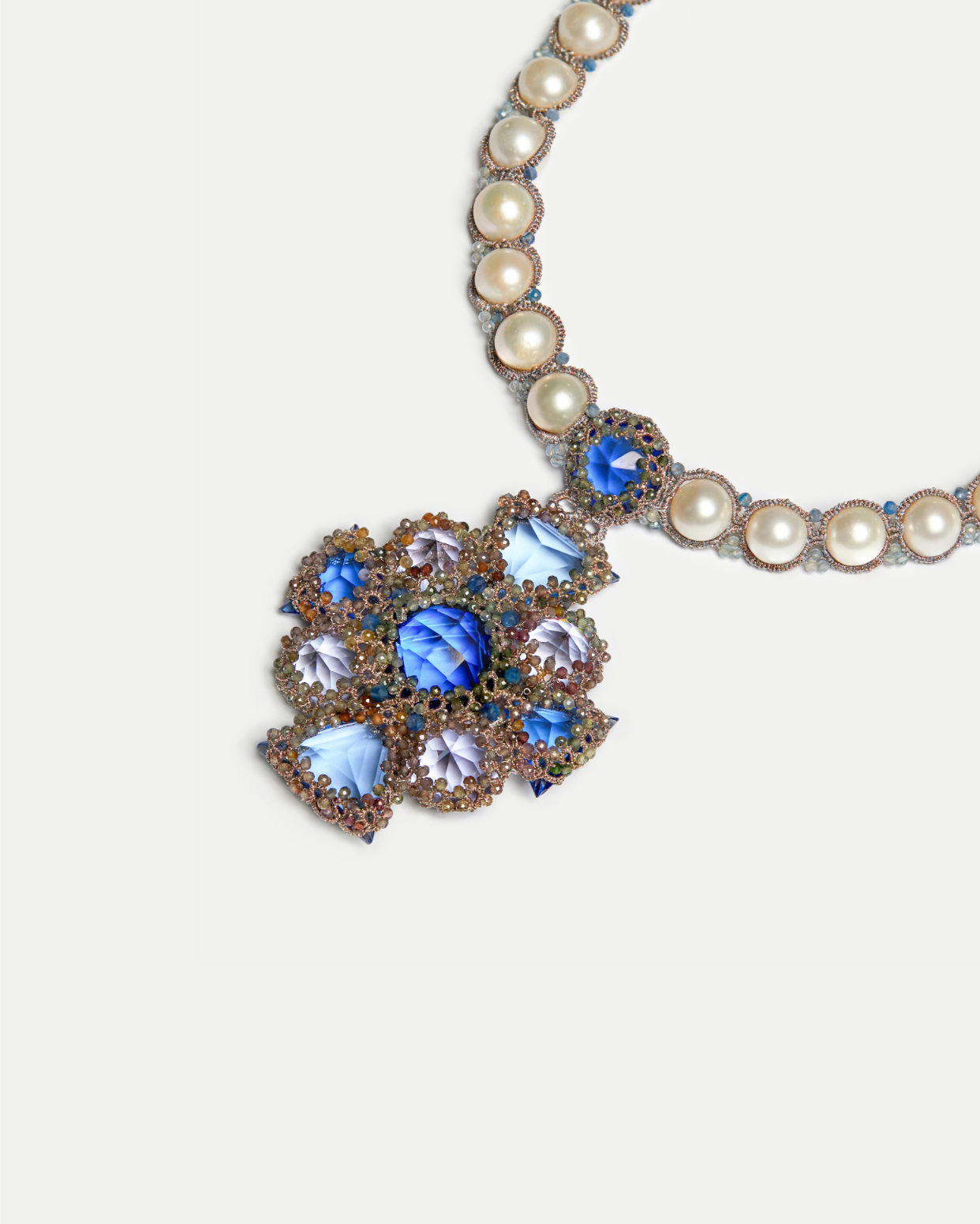 Necklace with purple silk cord, pearl beads, and blue gemstone details, showcasing intricate craftsmanship.