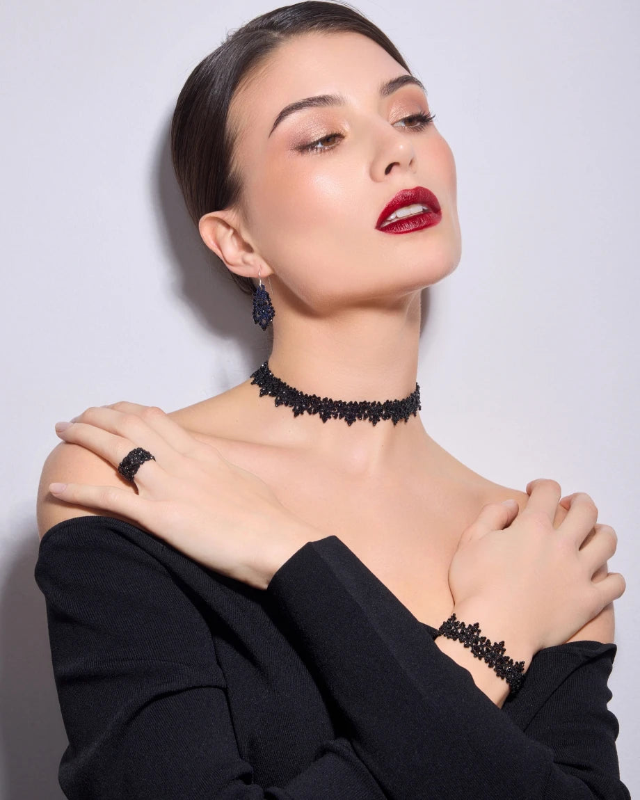 Black silk and pearl AIRA choker with intricate texture detailing.