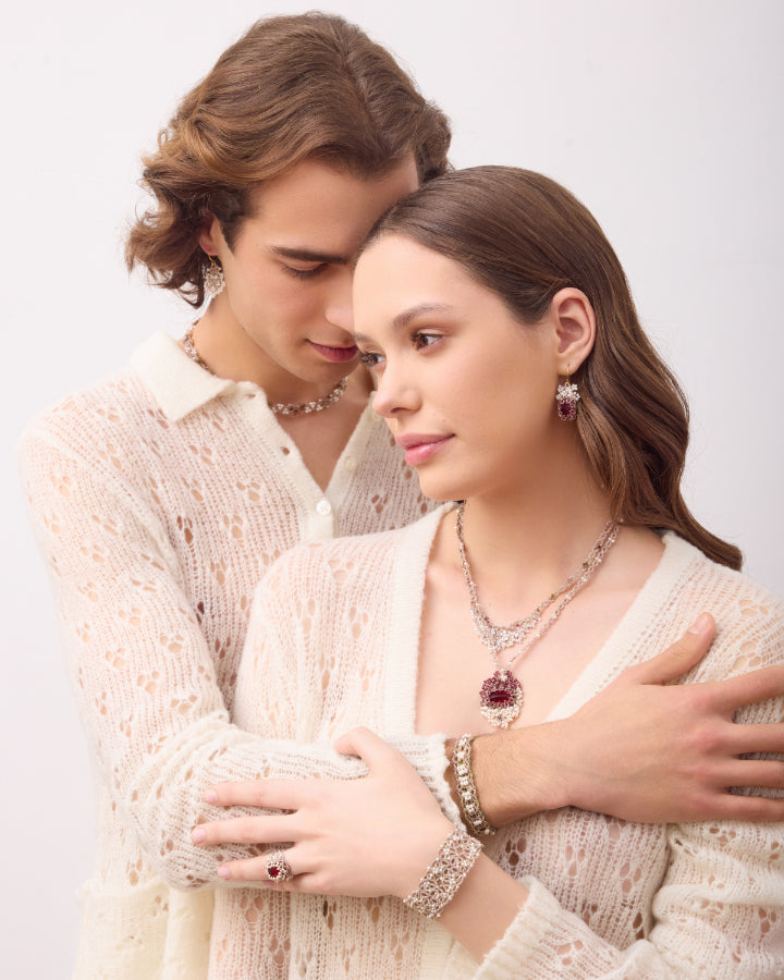 ALEA BRACELET in white with intricate woven design on wrist, paired with beaded necklaces and earrings.