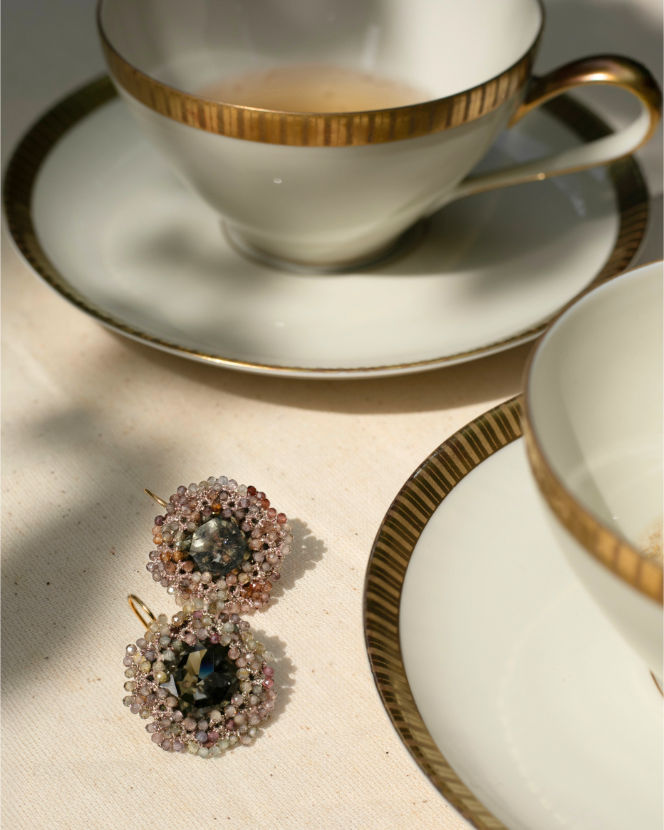 ANDRA Earrings with multicolor crystals, sapphire gemstones, gold hooks on creamy tablecloth.