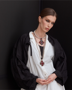 ANYA PENDANT with red crystals, freshwater pearls, silk thread, worn over white blouse and black jacket.