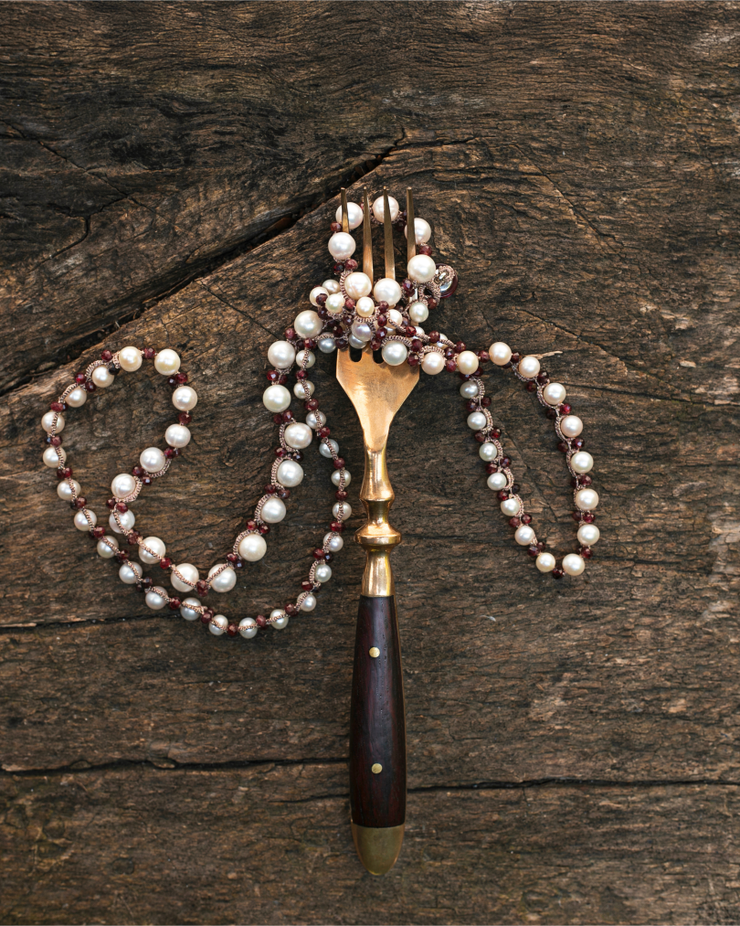 ATENA PENDANT with freshwater pearls, garnet gemstones, red silk threads on rustic wood surface.