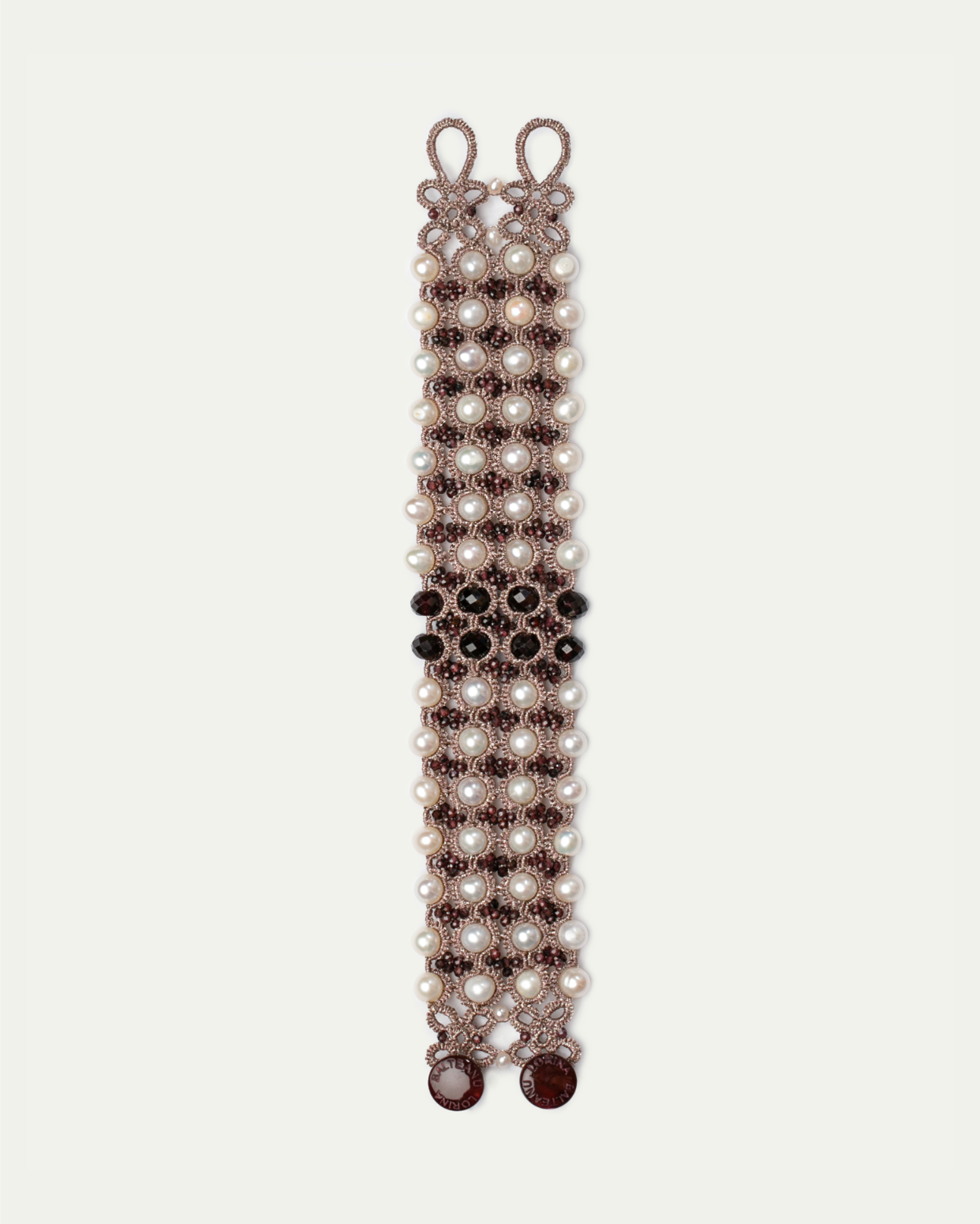 Red Beatrice bracelet with pearl beads and intricate woven detailing, featuring elegant side view angle.