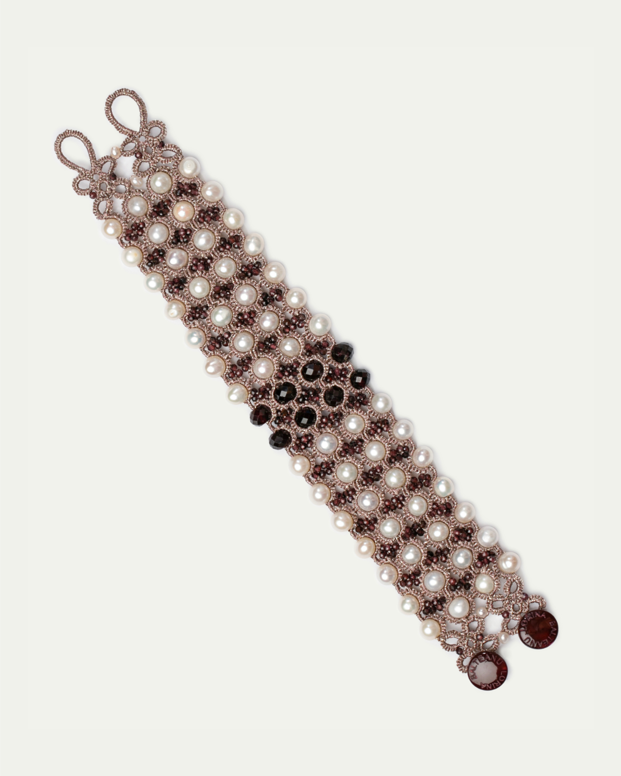 Pearl and black bead bracelet with intricate silk detailing in a red hue, featuring elegant interwoven patterns.