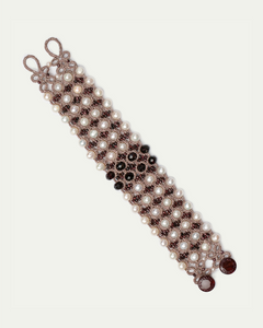 Pearl and black bead bracelet with intricate silk detailing in a red hue, featuring elegant interwoven patterns.