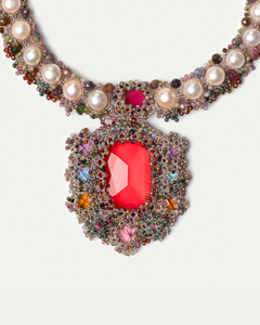 Multicolored silk necklace with large red gemstone, pearls, and small colorful beads detailing.