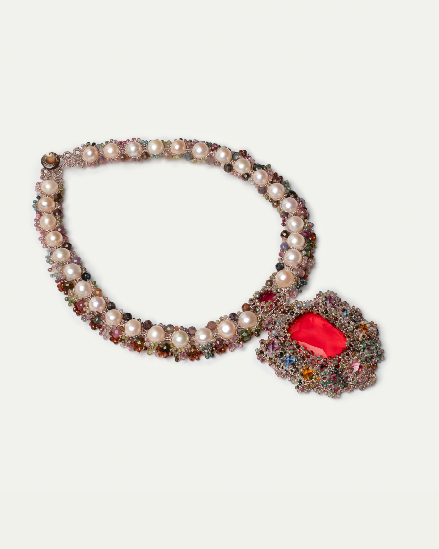 Silk necklace with pink pearls and colorful beads, featuring a bold red gemstone centerpiece.