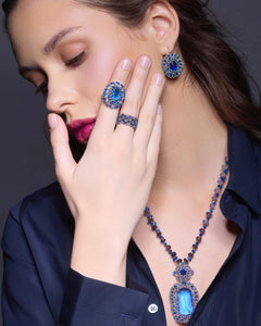 Blue silk and kyanite Claudia pendant with pearl and glass detailing, worn with matching earrings and ring.
