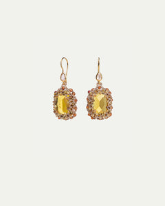 Gold Constance earrings with faceted crystal centerpiece, silk details, and garnet accents.