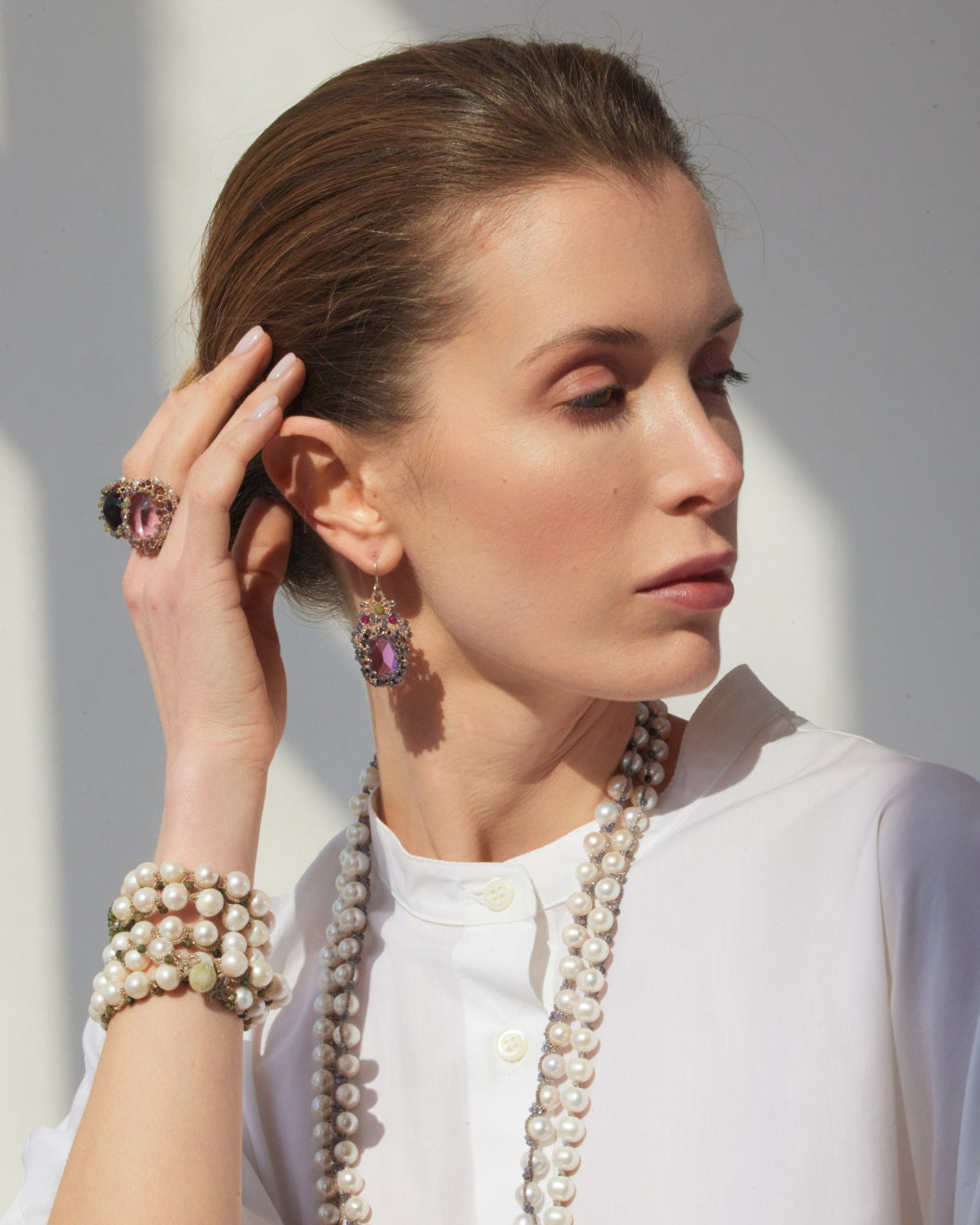 Rose silk earrings with gold and sapphire details, worn by a model.