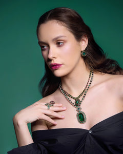 Green garnet earrings with gold and crystal detailing, worn with matching necklace and rings on model.