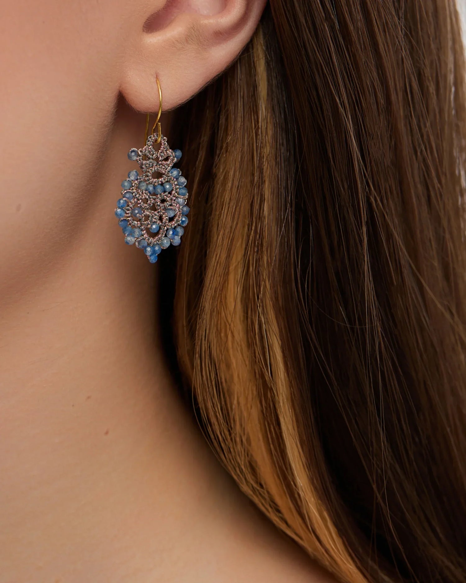 Blue Donna earrings with intricate design, featuring small blue gemstones and gold hooks, side view.