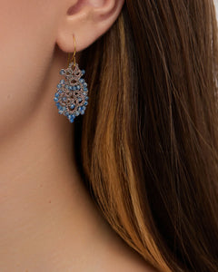 Blue Donna earrings with intricate design, featuring small blue gemstones and gold hooks, side view.