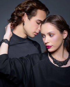 Black silk and silver Dora earrings with intricate texture, worn with matching necklace and bracelet, close-up view.