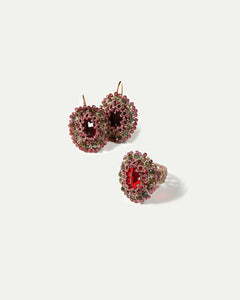 Red silk earrings with gold hooks, adorned with garnet and crystal detailing, intricate texture.
