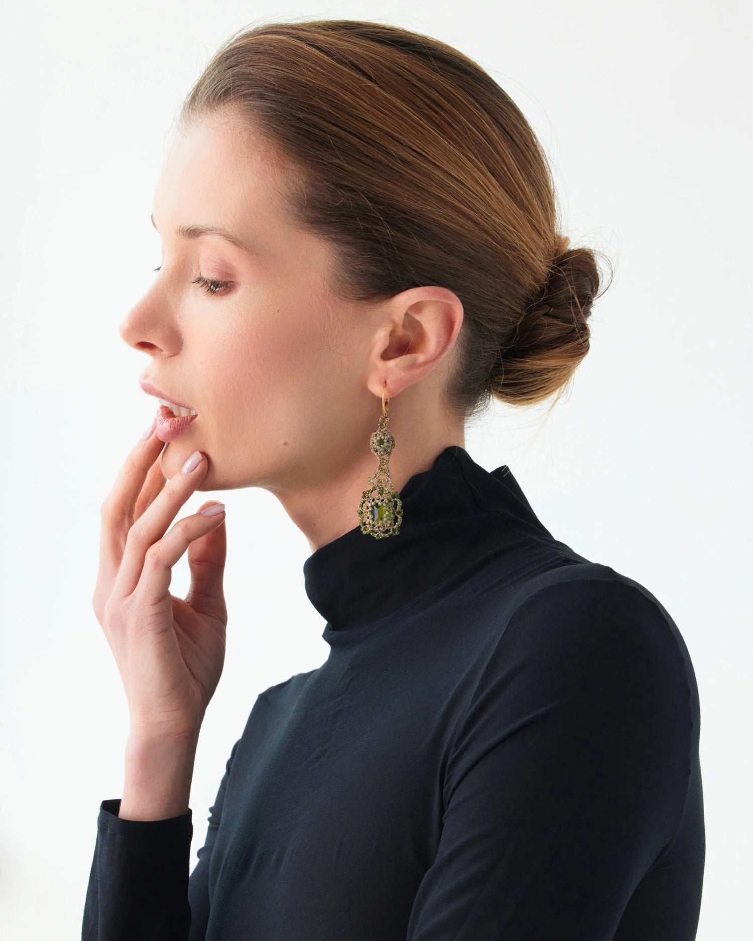 Green ELOISE earrings with silk, gold, silver, crystal, and tourmaline detail, worn by a model in black top.