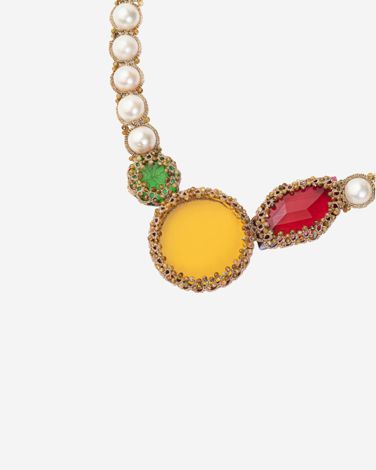 Jewelry detail with pearls, yellow and red gemstones, and green embellishments on gold settings.