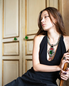 Elegant necklace with pearls, crystals, sapphire, and garnet, featuring detailed silk texture and vibrant colors.