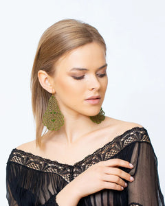Silk gerbera earrings in green with gold and silver accents, intricate texture, worn by model with lace top.