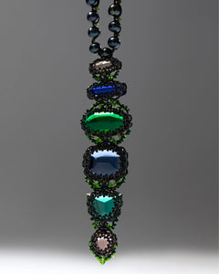 Black freshwater pearl necklace with faceted glass and pearl details, intricate beadwork, green accents.