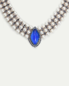 Blue kyanite pendant surrounded by freshwater pearls and silk threading on Hepburn necklace detailing.