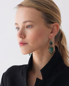Green INESSE earrings with intricate design, side view, worn by model in black outfit, showcasing detailed craftsmanship.