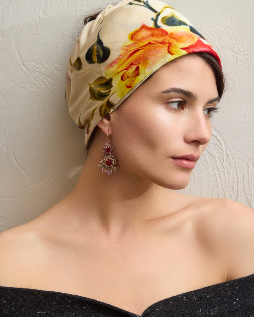 Red silk Kimberly earrings with intricate detailing, worn by a model with a floral headscarf.
