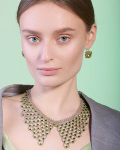 Green Lorelei earrings with intricate design, paired with matching necklace, textured material, elegant side angle.