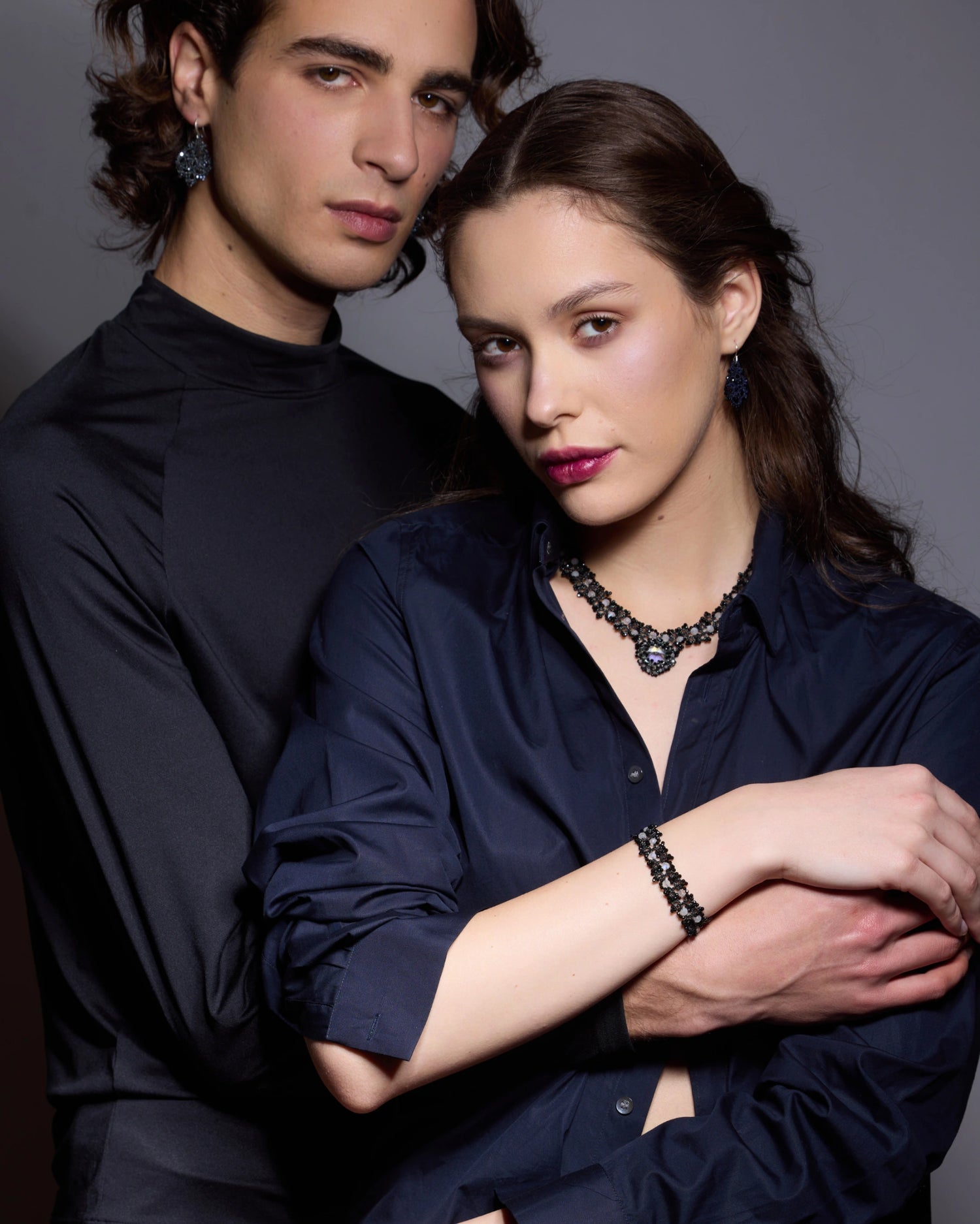 MARGUERITTE BRACELET with spinel, moonstone, silk threads, black color, on wrist of model wearing dark shirt.