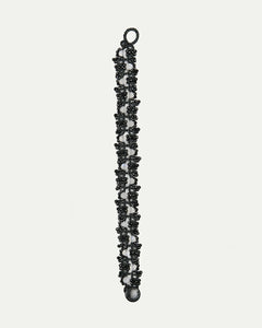 Black Margueritte bracelet side view, intricate lace design, black beads, interwoven details, elegant clasp.