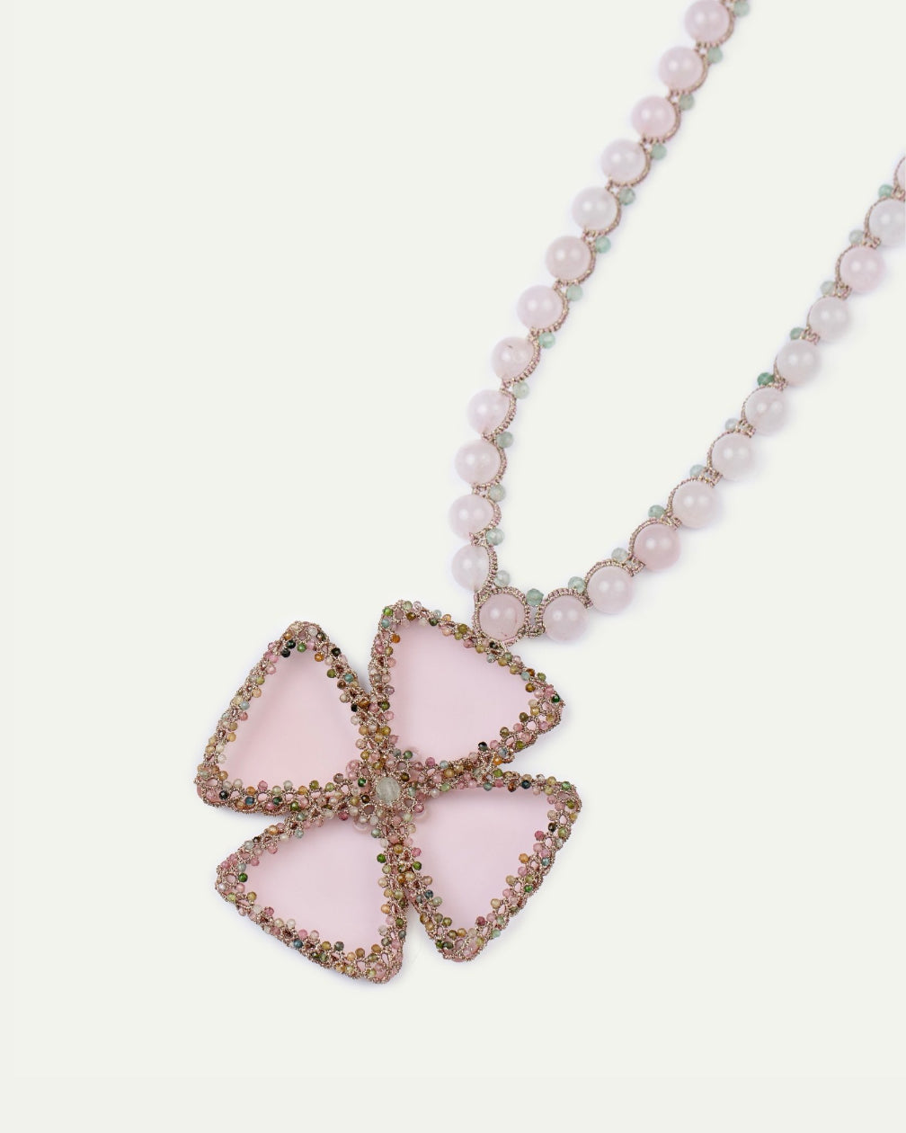 Rose pendant with silk, pearl, opal, tourmaline beads, and glass details; intricate petal design.