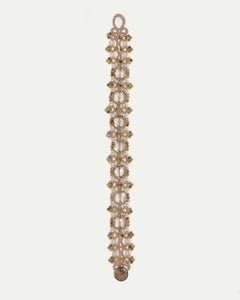 Gold PAIGE bracelet with intricate beadwork, featuring large clear gemstones interspersed with smaller accents.