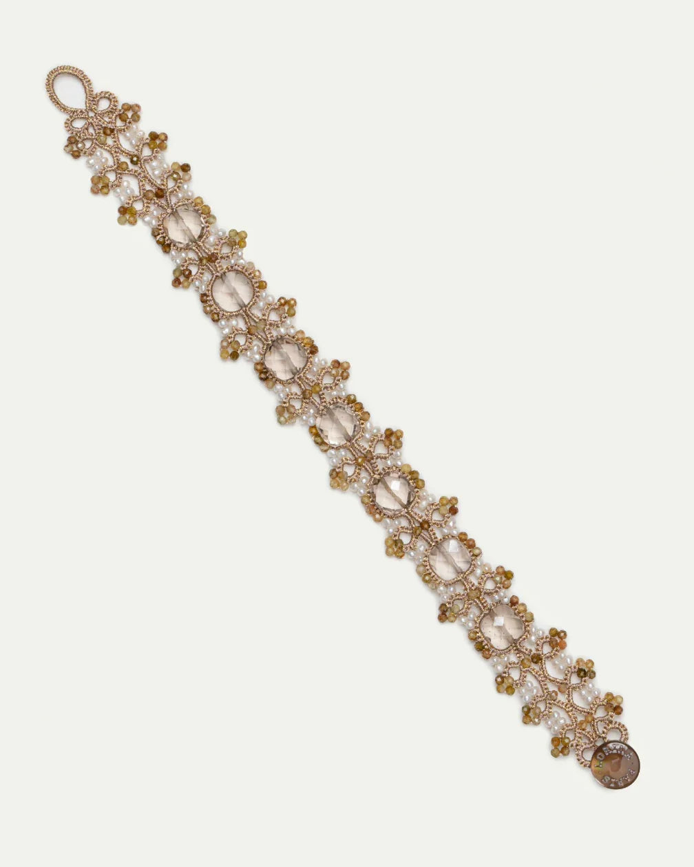 Gold PAIGE bracelet with silk, freshwater pearls, garnet, intricate detailing, and luxurious texture.