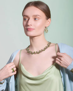 Green silk and silver earrings with pearls and tourmaline detail worn by model.