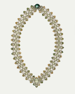 Green PAIGE necklace with ornate beaded pattern, featuring pearls and a central gemstone in a delicate woven design.