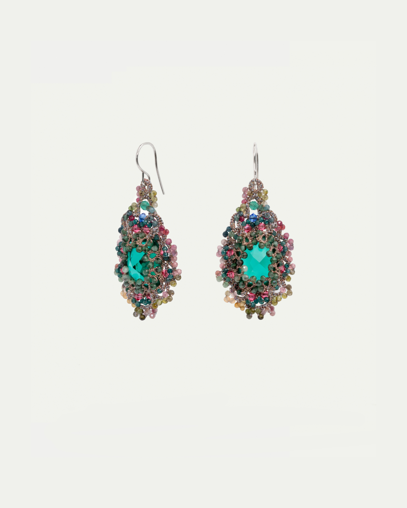 Green earrings with silk, crystal, pearl, sapphire, emerald details; intricate texture and vibrant colors.