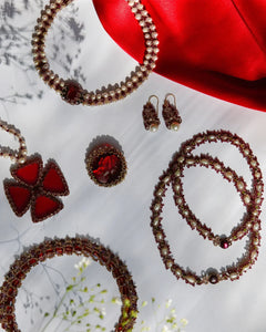 Red silk and pearl detail with sapphire accents on Penelope brooch, showcasing intricate craftsmanship.